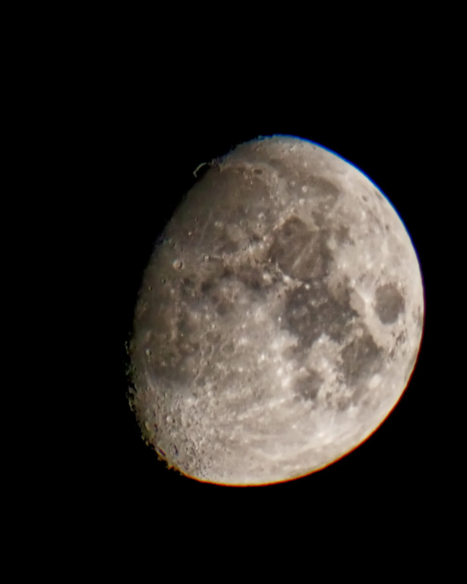 Zunehmender Mond mit scharf abgebildeter Kraterlandschaft, freigestellt vor komplett schwarzem Nachthimmel.