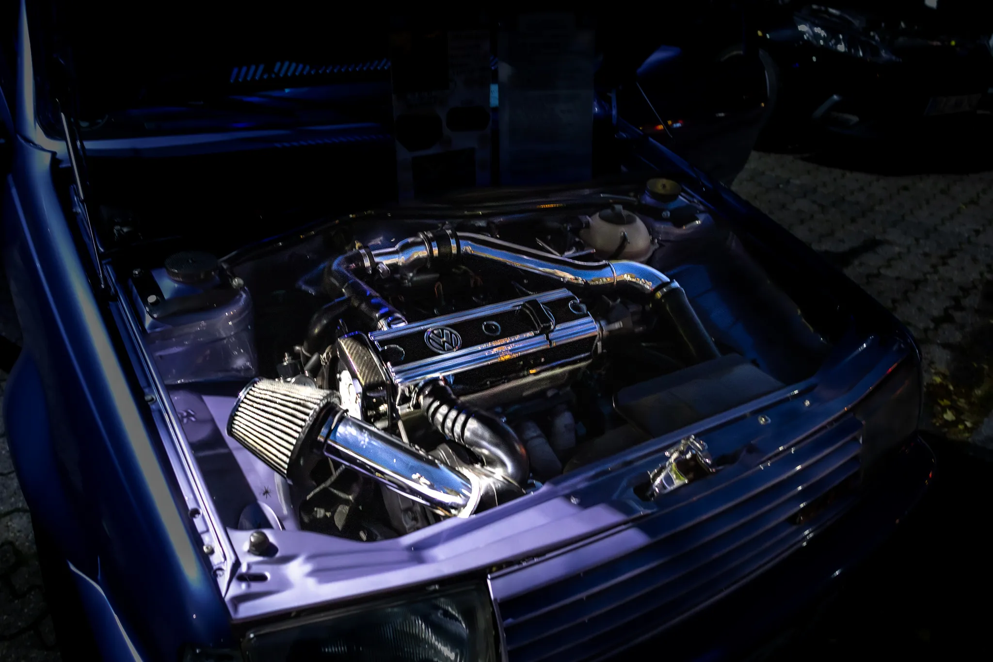Weißer Ford Mustang Shelby GT500 mit roten Rennstreifen, Startnummer 4 und Hoosier-Slicks, auf der Startbahn fahrend.